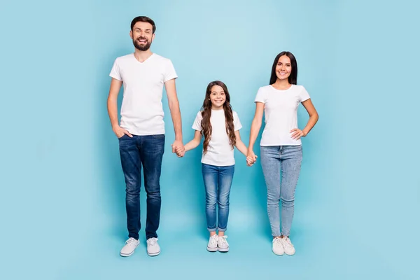 明るいコンテンツのフルボディ写真ブルネットの髪のホールド手で大きな3人は家族の日の休日を楽しむパステルブルーの色の背景に隔離された白いTシャツデニムジーンズスニーカーを着用 — ストック写真