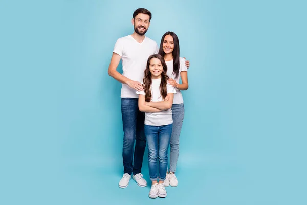 Pełna długość zdjęcie idylliczne mama tata i potomstwo z brunet włosów przytulić cieszyć nosić biały t-shirt dżinsy trampki casual strój izolowany na niebieskim tle — Zdjęcie stockowe