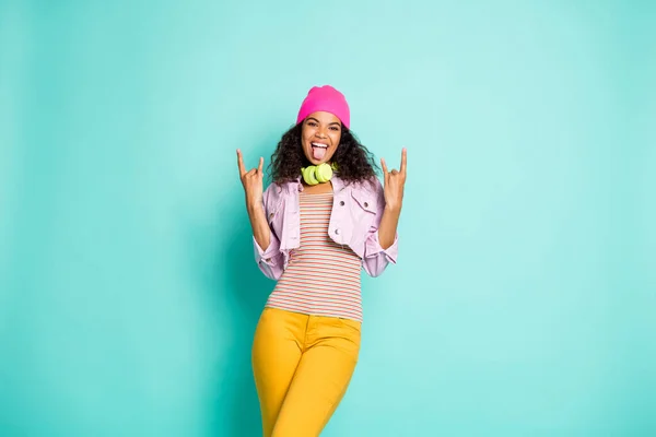 Foto van vrolijke casual leuke charmante vriendin tonen steen teken steken tong uit dragen jas gestreepte t-shirt broek geel geïsoleerde pastel kleur achtergrond teal — Stockfoto