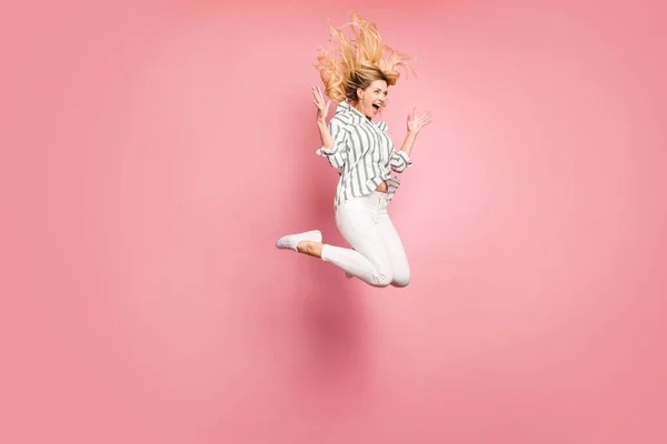 Volledige lengte lichaamsgrootte draaide foto van dolblij vrolijke vriendin gooien haar haar omhoog geblazen met win dragen broek geïsoleerde pastel kleur achtergrond — Stockfoto