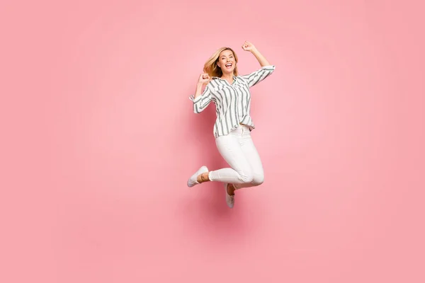 Full length body size photo of charming crazy ecstatic overjoyed woman wearing trousers pants jumping up isolated pastel color background