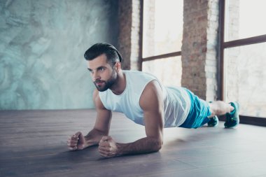 Profile photo of macho sportsman guy doing plank on elbows hands leaning floor determined sportswear tank-top shorts sneakers training house studio windows indoors clipart