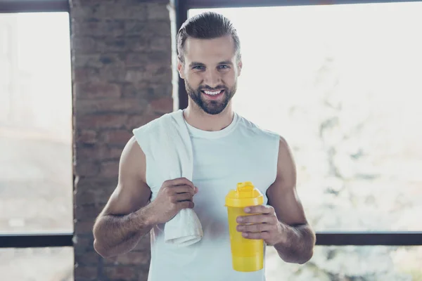 Photo of handsome sportsman trainer guy wait morning practicing hold water bottle towel friendly smiling sportswear tank-top training house studio windows indoors — Stock Photo, Image