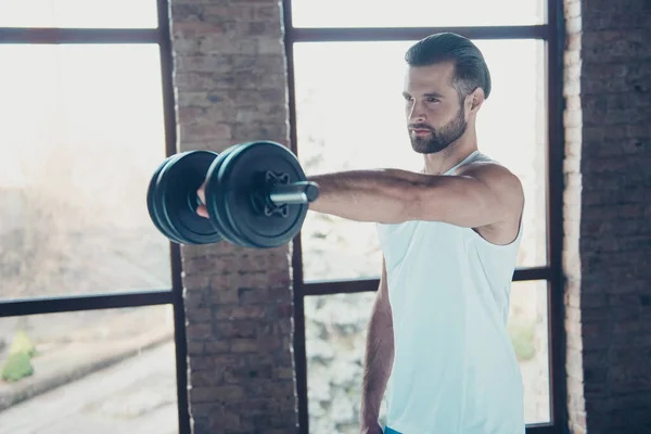 Profile photo of handsome hot beard guy morning training biceps muscles lift heavy dumbbell tempting eyes look sportswear tank-top training house studio big windows indoors — Stock Photo, Image