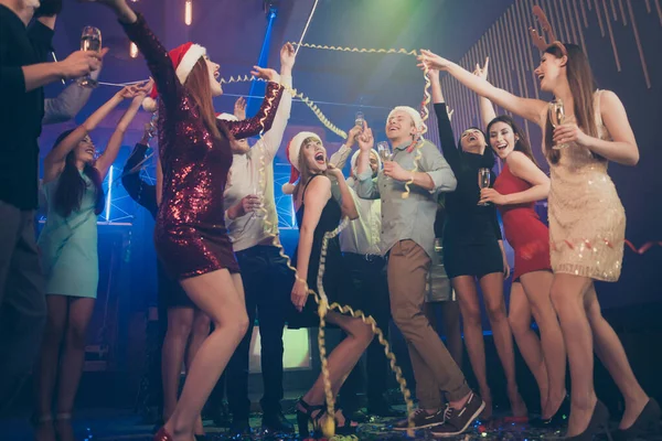 Полночный отсчет до 2020 года. Весёлая позитивная кричащая большая группа красивых дам наслаждающихся новым годом веселыми тостами поднимающими руки танцующими на танцполе — стоковое фото