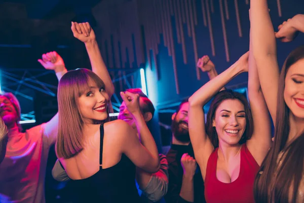 Zdjęcie radosnych studentów korporacji spędzających czas w nocnym klubie świętując dzień studencki pokazujący ich szaleństwo w tańczeniu w neonowych światłach — Zdjęcie stockowe