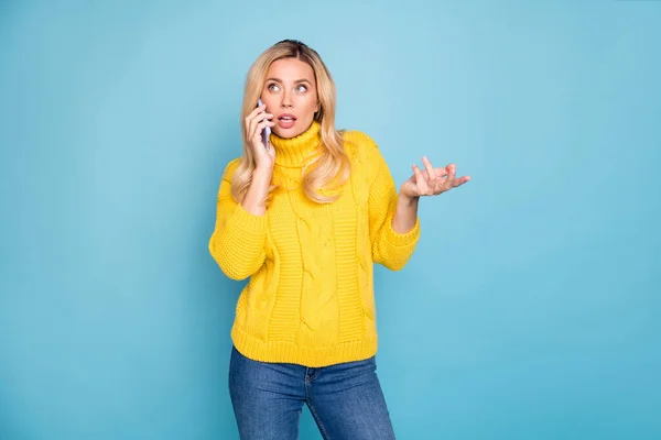 Foto di incredibile signora bionda che tiene il telefono parlando con fidanzato umore giocoso usura maglia gialla pullover jeans isolato colore blu sfondo — Foto Stock