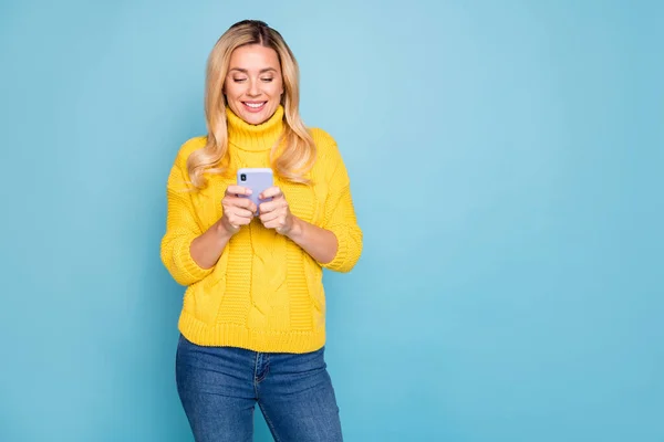 Photo of amazing blond lady holding telephone hands texting comments feednews wear knitted yellow pullover jeans isolated blue color background — Stock Photo, Image