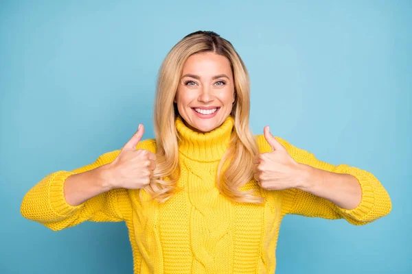 Photo of amazing pretty blonde lady raise thumbs up expressing positive agree attitude új termék meleg kötött sárga jumper elszigetelt kék háttér — Stock Fotó