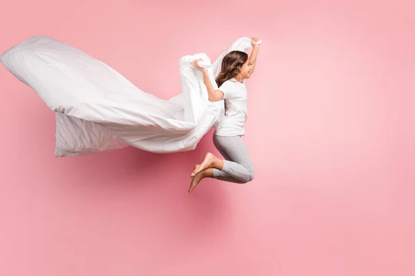 Full length body size view of nice attractive childish careful cheerful cheerful wavy-haired pre-teen girl jumping with blanket ghost isolated over pink pastel color background — стоковое фото