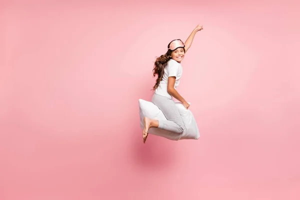 Full length body size view of nice attractive childish playful comic cheerful cheery wavy-haired pre-teen girl jumping riding pillow purpose goal party isolated over pink pastel color background — Stock Photo, Image