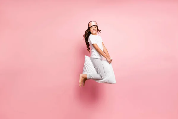 Comprimento total tamanho do corpo vista dela ela agradável atraente infantil brincalhão alegre alegre alegre alegre cabelo ondulado pré-adolescente menina saltar equitação travesseiro partido isolado sobre rosa pastel cor fundo — Fotografia de Stock