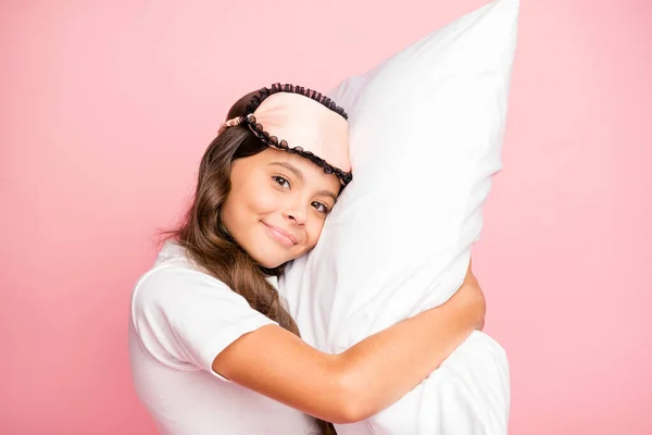 照片上躺着快乐、积极、放松的女孩正准备上床睡觉，她戴着夜膜，抱着枕头，有着孤立的彩色背景 — 图库照片