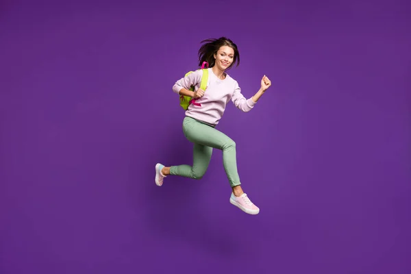 Longitud completa vista del tamaño del cuerpo de agradable atractivo alegre alegre alegre adolescente saltando corriendo a la escuela secundaria aislado en brillante brillo vivo vibrante violeta violeta lila color de fondo —  Fotos de Stock