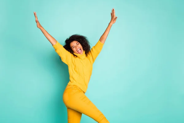 Profile photo of cool dark skin lady holding hands raised walking down street childish mood wear yellow knitted pullover stylish pants isolated blue teal color background — Stockfoto