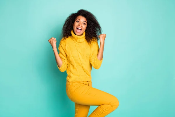 Photo of cool dark skin lady holding hands raised celebrating birthday midnight coming wear yellow knitted pullover stylish pants isolated blue teal color background — Stockfoto