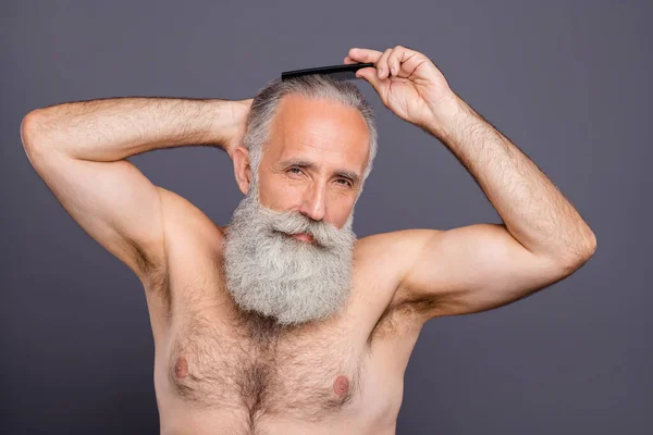 Φωτογραφία του ελκυστικού όμορφος macho γέρος παππούς χτένισμα τα μαλλιά του για να πάει έξω με τη γιαγιά απομονωμένη πάνω από γκρι φόντο χρώμα — Φωτογραφία Αρχείου