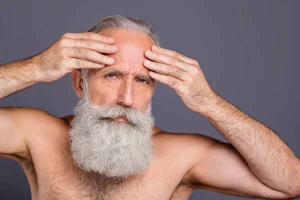 Photo of thinking old white man smoothing his forehead worried about wrinkles on it willing to rejuvenate himself isolated over grey color background — Stock Photo, Image