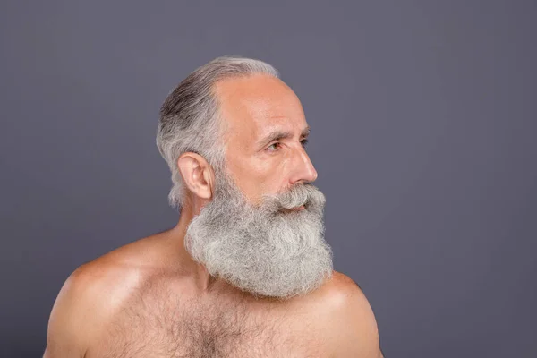 Foto von selbstbewussten ernsthaften gut aussehenden alten Mann, der wegschaut und perfekte Arbeit seines Friseurs zeigt, isoliert über grauem Hintergrund — Stockfoto