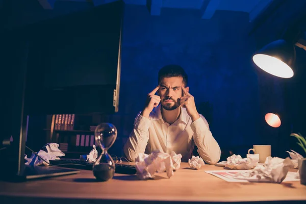 Photo of pensive overwhelmed business man doing overtime work displeased with result of his brainstorming thoughts with crumpled paper around on table — Stock Photo, Image