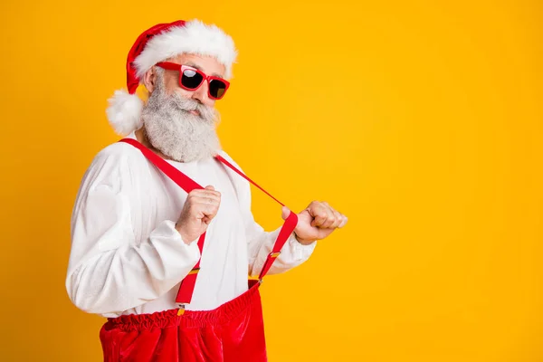 Portret van koele zelfverzekerde santa claus moderne hipster vieren kerst feest tijd trek rode bretels geïsoleerd over glans kleur achtergrond — Stockfoto