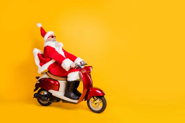 Full body foto van santa wit haar opa paardrijden snelheid x-mas partij door fiets bang om te laat dragen trendy zon specs rode jas broek pet shirt laarzen geïsoleerde gele kleur achtergrond — Stockfoto