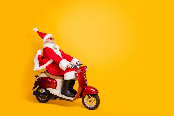 Pełna długość profil zdjęcie Santa białe włosy dziadek jazda prędkość x-mas party przez rower nosić modne okulary okulary czerwony płaszcz spodnie czapka buty odizolowany żółty kolor tło — Zdjęcie stockowe