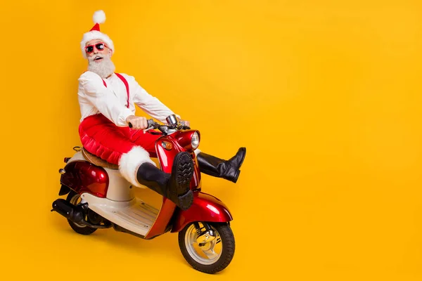 Full body foto van grappige santa wit haar opa haasten Nieuwjaar feest snelheid retro fiets dragen trendy zon specs rode broek cap shirt laarzen geïsoleerde gele kleur achtergrond — Stockfoto