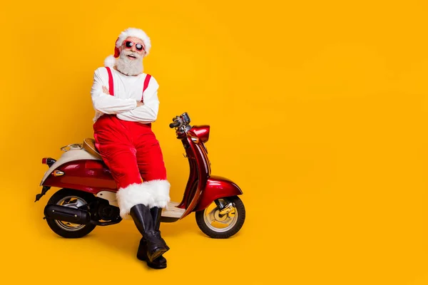 Noel Baba 'nın tam vücut fotoğrafı, şenlik havası, Noel partisi, retro bisiklet dinleme şakaları, güneş gözlüklü pantolon şapkalı botlar, izole edilmiş sarı arka plan. — Stok fotoğraf