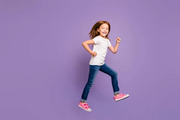Ganzkörperprofil Foto von lustigen kleinen foxy Dame springen hohe Freude rauschenden Einkaufsrabatten Geschwindigkeit tragen lässige T-Shirt Jeans isoliert lila Hintergrund — Stockfoto