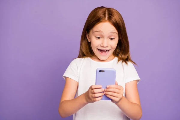 Foto de una señora bastante pequeña y atractiva sosteniendo las manos del teléfono revisando el blog de los niños emocionados con muchos nuevos seguidores. Los suscriptores usan una camiseta blanca de fondo púrpura aislado. — Foto de Stock