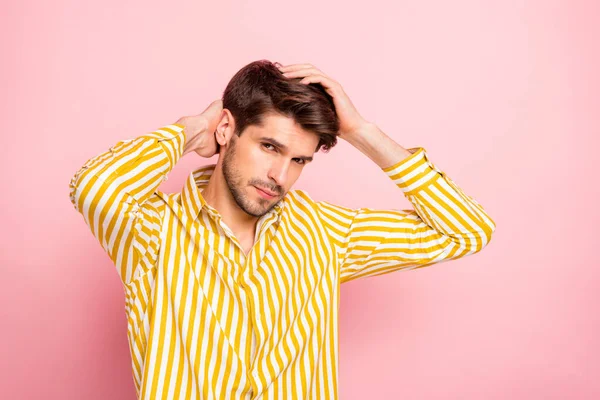 Foto de chico guapo cogido de la mano en el concepto de tratamiento de belleza peinado perfecto mirando seriamente en la cámara de desgaste camisa de rayas hipster aislado de color rosa de fondo — Foto de Stock