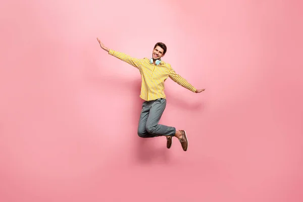 鳥のように飛ぶ耳フラップを使用して夏の時間を楽しむ高ジャンプハンサムな男の完全な長さの写真ヒップスターストライプシャツパンツ孤立ピンク色の背景 — ストック写真