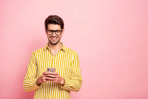 写真のハンサムな男タイプのガールフレンドsms保持電話社会中毒者は、仕様を身に着けているヒップスターストライプシャツ孤立ピンク色の背景 — ストック写真