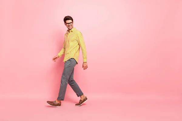 Full size foto profilo di bel ragazzo d'affari che scende strada finito settimana lavorativa usura specifiche elegante camicia a righe pantaloni isolato colore rosa sfondo — Foto Stock