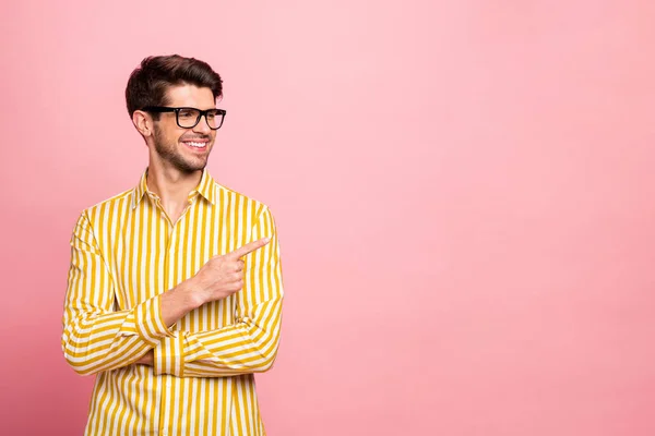 Zdjęcie przystojnego faceta patrząc wskazując palec do pustej przestrzeni doradzając chłodną cenę sprzedaży oferta zakupy nosić specyfikacje stylowe paski koszulka odizolowany różowy kolor tło — Zdjęcie stockowe