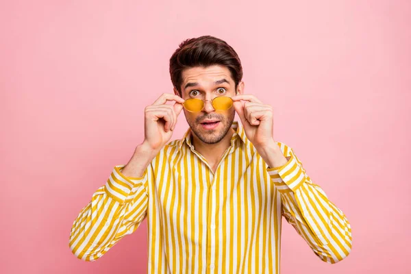 Foto de guapo macho chico buscando estupor tomando gafas no creo ojos precios bajos desgaste sol especificaciones elegante rayas camisa aislado rosa color fondo — Foto de Stock