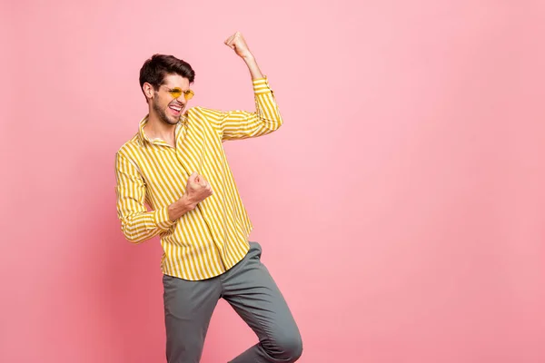 Zdjęcie przystojny macho facet świętuje fajne zwycięstwo podnoszenie pięści krzycząc chętnie nosić okulary stylowe paski spodnie odizolowane różowy pastelowy kolor tła — Zdjęcie stockowe