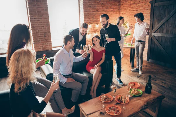 Foto de festa de aniversário festiva positiva pessoas amizade bate-papo clinking copos beber vinho dourado comer lanches usar formalwear sentado sofá-loft quarto dentro de casa — Fotografia de Stock