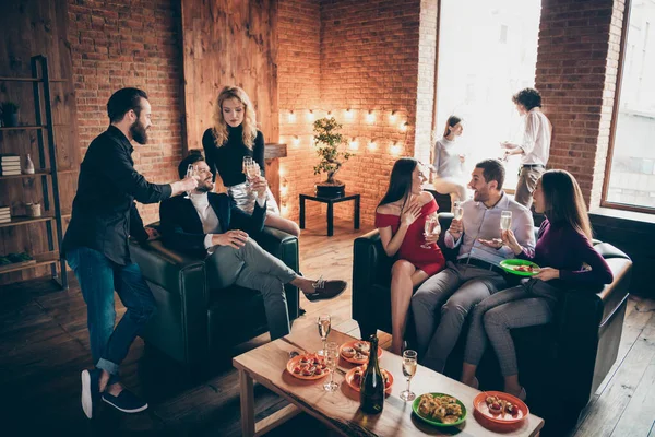 Photo of eight members group festive birthday party people friendship chatting clinking glasses drink golden wine eating snacks wear formalwear sitting sofa indoors — Stock Photo, Image