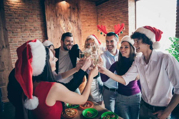 Foto av grupp möte x-mas fest många människor firar klinkande vinglas dricka mousserande vin slitage formalwear Santa hattar rådjur horn står runt bordet inomhus — Stockfoto