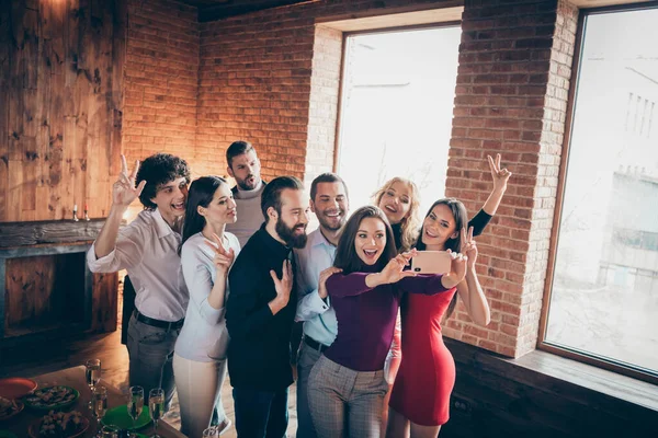 Portrait of nice attractive positive cheerful cheery glad people enjoying meeting making taking selfie showing v-sign having fun at modern industrial brick wood loft style interior house indoors — Stock Photo, Image