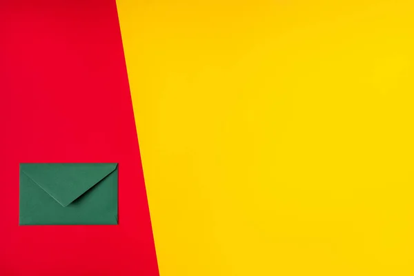 Ovanför hög vinkel visa foto av grönt papercard brev flatlay isolerad över röd gul färg bakgrund skickas för jul bröllop födelsedag fest högtid — Stockfoto