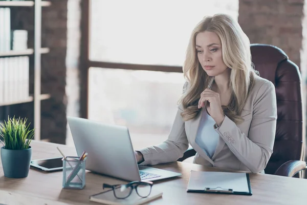 Фото дивовижної блондинки бізнес леді винахідливої людини, яка серйозно виглядає зошитом на столі сидячий бос стілець формальний одяг Блейзер в сучасному офісі — стокове фото