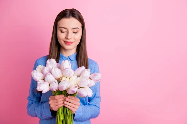 Foto de uma senhora incrível segurando grandes tulipas brancas frescas em mãos fechando os olhos de alegria usar camisa pontilhada azul isolado cor de fundo rosa — Fotografia de Stock