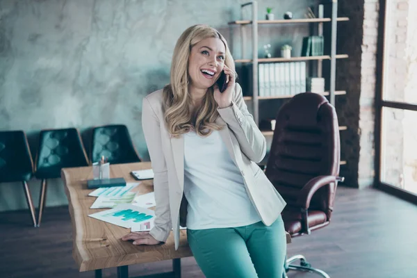 Фото красивой позитивной деловой леди шеф держать телефон беседуя с партнерами корпоративного обсуждения стартап проекта формальной одежды пиджак брюки современный офис — стоковое фото