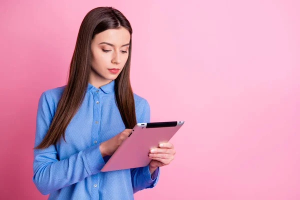 Copysapce foto av attraktiv entreprenör bläddra igenom hennes tablett på jakt efter information inreasing inkomst hålla den med händerna bär blå skjorta isolerad rosa pastell färg bakgrund — Stockfoto