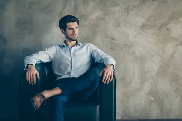 Profiel kant portret van ernstige minded elegante zakenman zitten op zwarte fauteuil kijken copyspace droom denken werk gedachten dragen moderne broek schoenen stijlvolle outfit geïsoleerde grijze kleur achtergrond — Stockfoto