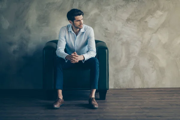 Volledige lengte profiel zijkant foto van doordachte ernstige mannelijke freelancer zitten zwart lederen fauteuil hebben werk gedachten droom look copyspace slijtage broek bruin schoenen geïsoleerde grijs kleur achtergrond — Stockfoto