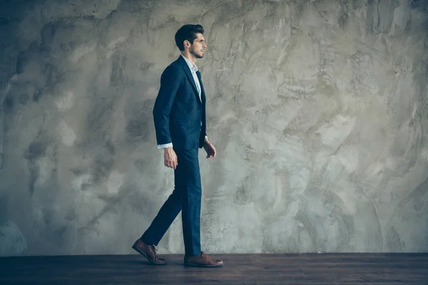 Volledige lengte lichaam grootte zijkant profiel foto van ernstige zelfverzekerde man lopen voorwaarts in schoenen met stoppel geïsoleerde grijze kleur achtergrond — Stockfoto